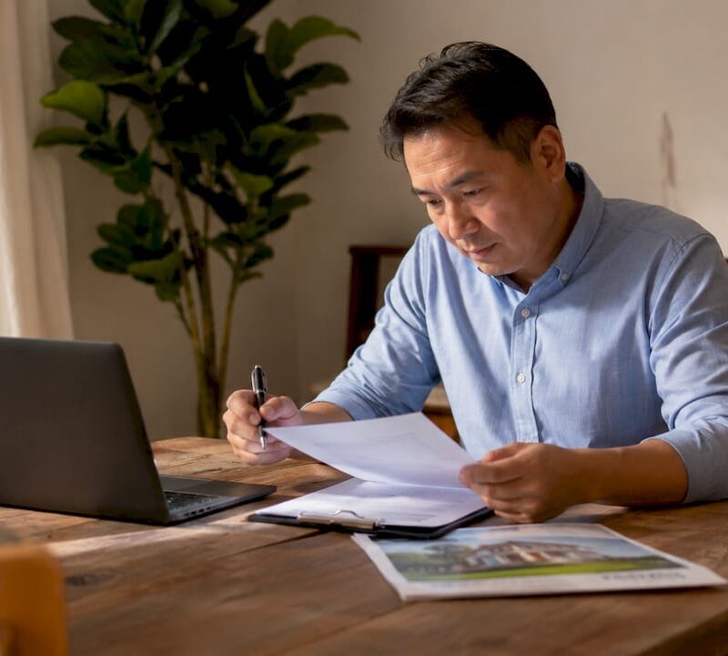 Homeowner reviewing property documents at dining table