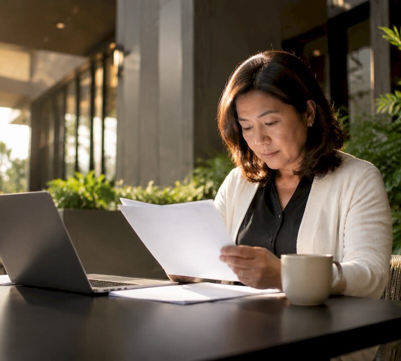 Woman reviewing property tenure documents at desk
