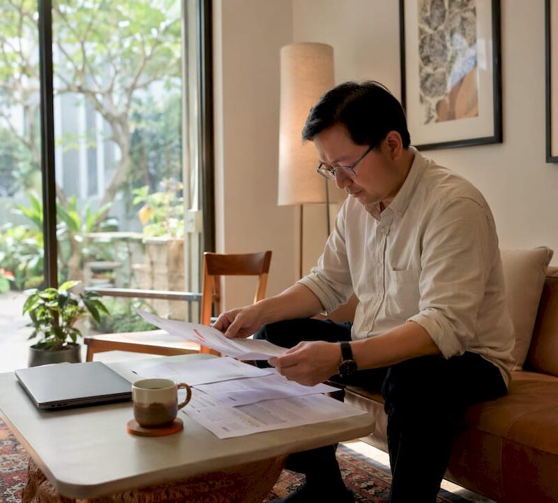 Man reviewing property documents in Singapore apartment