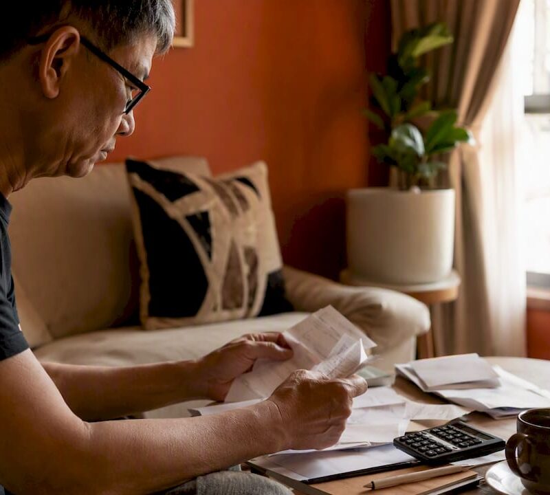 Hands sorting rental tax documents at home table