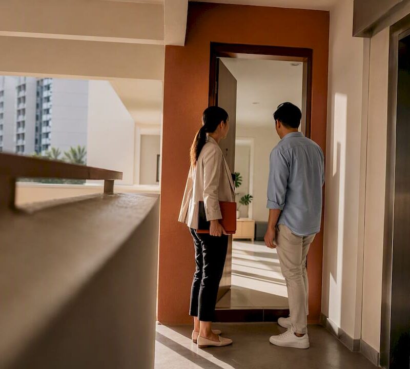 Agent and buyer at HDB resale flat entrance
